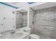 Well-lit bathroom with a tiled shower, grab bars, and classic white fixtures at 1227 56Th St W # 1227, Bradenton, FL 34209