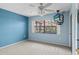 Bright bedroom featuring a large window, ceiling fan, and neutral carpeting at 1227 56Th St W # 1227, Bradenton, FL 34209