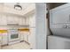 Functional kitchen with white cabinetry, appliances, and laundry closet nearby at 1227 56Th St W # 1227, Bradenton, FL 34209