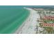 Stunning aerial view of a pristine white sand beach next to beachfront condos and turquoise water at 1250 N Portofino Dr # 208, Sarasota, FL 34242