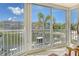 Serene enclosed balcony showcasing a canal view, ample natural light, and a peaceful seating area for relaxation at 1250 N Portofino Dr # 208, Sarasota, FL 34242