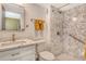 Bathroom featuring white vanity, toilet, and marble-patterned standing shower with built-in grab bars at 1250 N Portofino Dr # 208, Sarasota, FL 34242