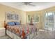Bedroom with wooden furnishings, fan, and windows creating a bright and airy space at 1250 N Portofino Dr # 208, Sarasota, FL 34242