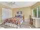 Bedroom featuring bright windows, desk, fan, and white closet space at 1250 N Portofino Dr # 208, Sarasota, FL 34242