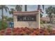 Siesta Harbor community sign amidst colorful flowers, palm trees, and well-manicured landscaping at 1250 N Portofino Dr # 208, Sarasota, FL 34242