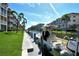 Waterfront condo community with boat docked on canal, lush landscaping, and stunning blue skies at 1250 N Portofino Dr # 208, Sarasota, FL 34242