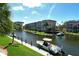 View of waterfront condos with boat docks, lush palms, and clear blue sky at 1250 N Portofino Dr # 208, Sarasota, FL 34242
