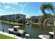 View of waterfront condo buildings with boat docks, lush palm trees, and beautiful clear blue sky at 1250 N Portofino Dr # 208, Sarasota, FL 34242