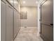 Bright hallway featuring gray storage cabinets and neutral tile floors leading to a doorway at 1250 N Portofino Dr # 208, Sarasota, FL 34242