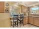 Kitchen area features a breakfast bar with seating, wood cabinetry, and granite countertops at 1250 N Portofino Dr # 208, Sarasota, FL 34242