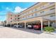 Exterior shot of a condo building featuring convenient covered parking with brick pavers and well-maintained landscaping at 1250 N Portofino Dr # 208, Sarasota, FL 34242