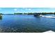 Scenic water view featuring a boat cruising along the calm canal, reflecting the blue sky at 1250 N Portofino Dr # 208, Sarasota, FL 34242