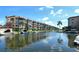 Scenic waterfront condos with boat docks lining a tranquil canal on a sunny day at 1250 N Portofino Dr # 208, Sarasota, FL 34242