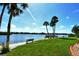 Scenic waterfront community park featuring lush grass, palm trees, benches, and water views at 1250 N Portofino Dr # 208, Sarasota, FL 34242