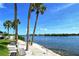 Scenic waterfront view with swaying palm trees and tranquil water enhancing the community's charm at 1250 N Portofino Dr # 208, Sarasota, FL 34242