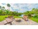 Community amenity area showcases a relaxing outdoor space with firepit, benches, and tranquil water views, perfect for gatherings at 137 Woodland Pl, Osprey, FL 34229