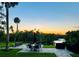 Community outdoor amenity area with outdoor seating, grill and water views offering an idyllic setting at sunset at 137 Woodland Pl, Osprey, FL 34229