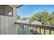 A sunny balcony view showing mature trees and a neighboring building at 137 Woodland Pl, Osprey, FL 34229