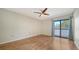 Light-filled bedroom with wood floors and sliding glass doors leading to a private balcony at 137 Woodland Pl, Osprey, FL 34229