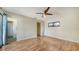 Bright bedroom featuring wood floors, neutral walls, and ceiling fan, adjoining a full ensuite bathroom at 137 Woodland Pl, Osprey, FL 34229