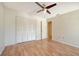 Spacious bedroom with wood floors, ceiling fan, and double door closet at 137 Woodland Pl, Osprey, FL 34229
