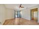 A bedroom features hardwood floors, a ceiling fan, and outdoor balcony access at 137 Woodland Pl, Osprey, FL 34229