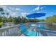 Relaxing deck area with bright patio furniture, table and umbrella, providing serene water views at 137 Woodland Pl, Osprey, FL 34229