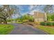 Attractive home exterior features a driveway, well-maintained landscaping, and mature trees against a backdrop of a serene lake at 137 Woodland Pl, Osprey, FL 34229