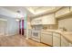 Well-lit kitchen featuring sleek white cabinetry, appliances, and wood-look flooring, with a breakfast nook at 137 Woodland Pl, Osprey, FL 34229