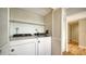 A laundry room features a white washer and dryer with storage shelves and hardwood floors at 137 Woodland Pl, Osprey, FL 34229