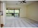 Spacious living room with a ceiling fan, new carpet and sliding glass door to outdoor patio at 137 Woodland Pl, Osprey, FL 34229