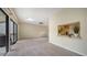 An open living area features carpet floors, a ceiling fan, and a view to the outdoor balcony at 137 Woodland Pl, Osprey, FL 34229