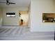 Bright living room featuring neutral carpet, lots of natural light, and an open view to the kitchen at 137 Woodland Pl, Osprey, FL 34229
