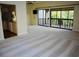 Open-concept living room with updated carpet, a ceiling fan, and a sliding glass door leading to a patio at 137 Woodland Pl, Osprey, FL 34229
