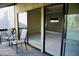 Private patio with comfortable seating and a sliding glass door into the spacious living room at 137 Woodland Pl, Osprey, FL 34229