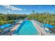 Inviting pool area featuring lounge chairs, umbrellas, and stunning water views, ideal for recreation and relaxation at 137 Woodland Pl, Osprey, FL 34229