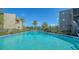 Community pool with clear water, lounge chairs, and mature landscaping, offering a relaxing oasis at 137 Woodland Pl, Osprey, FL 34229