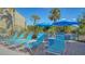 Community pool deck with comfortable lounge chairs and blue umbrellas offer a relaxing place to unwind at 137 Woodland Pl, Osprey, FL 34229