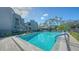 Community pool with a shallow end, sunny sky, and complex buildings in the background at 137 Woodland Pl, Osprey, FL 34229