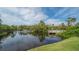 Scenic water view features a fountain, a wooden dock, and lush tropical vegetation creating a serene and picturesque landscape at 137 Woodland Pl, Osprey, FL 34229