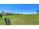 Community dog park featuring a bench, lake view, palm trees, and ample room for recreational activities at 16546 San Nicola Pl, Bradenton, FL 34211