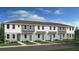 New modern townhomes featuring vertical siding, and individual covered entrances with light blue doors at 16546 San Nicola Pl, Bradenton, FL 34211