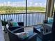 A screened balcony featuring wicker furniture offers serene lake views at 16804 Vardon Ter # 307, Bradenton, FL 34211