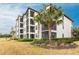 Multi-story condo building has screened balconies with mature palm trees in the foreground at 16804 Vardon Ter # 307, Bradenton, FL 34211