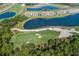 Scenic aerial view of a golf course with a water hazard, sand traps, and condos in the background at 16804 Vardon Ter # 307, Bradenton, FL 34211