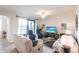 Inviting living room with comfortable seating, TV, and sliding door to a balcony at 16804 Vardon Ter # 307, Bradenton, FL 34211