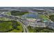 Overhead view of the community with a lake, golf course, and apartment buildings in the background at 17632 Santorini Ct, Venice, FL 34293