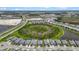 Aerial view of new homes in a community near roadways, a pond, and a large green space at 17632 Santorini Ct, Venice, FL 34293
