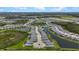 An aerial view of a Primary-planned community shows homes, water features and manicured landscaping at 17632 Santorini Ct, Venice, FL 34293