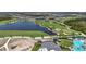 Beautiful aerial view of a golf course community featuring a lake, golf course and clubhouse at 17632 Santorini Ct, Venice, FL 34293